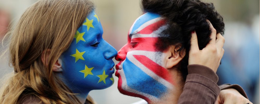 Two activists with the EU flag and Union Jack painted on their faces kiss each other in front of Brandenburg Gate to protest against the British exit from the European Union, in Berlin, Germany, June 19, 2016. REUTERS/Hannibal Hanschke